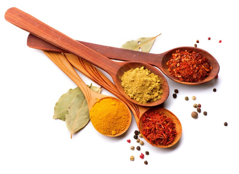 Wooden spoons filled with colorful spices